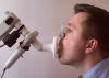 A young man testing breathing function by spirometry